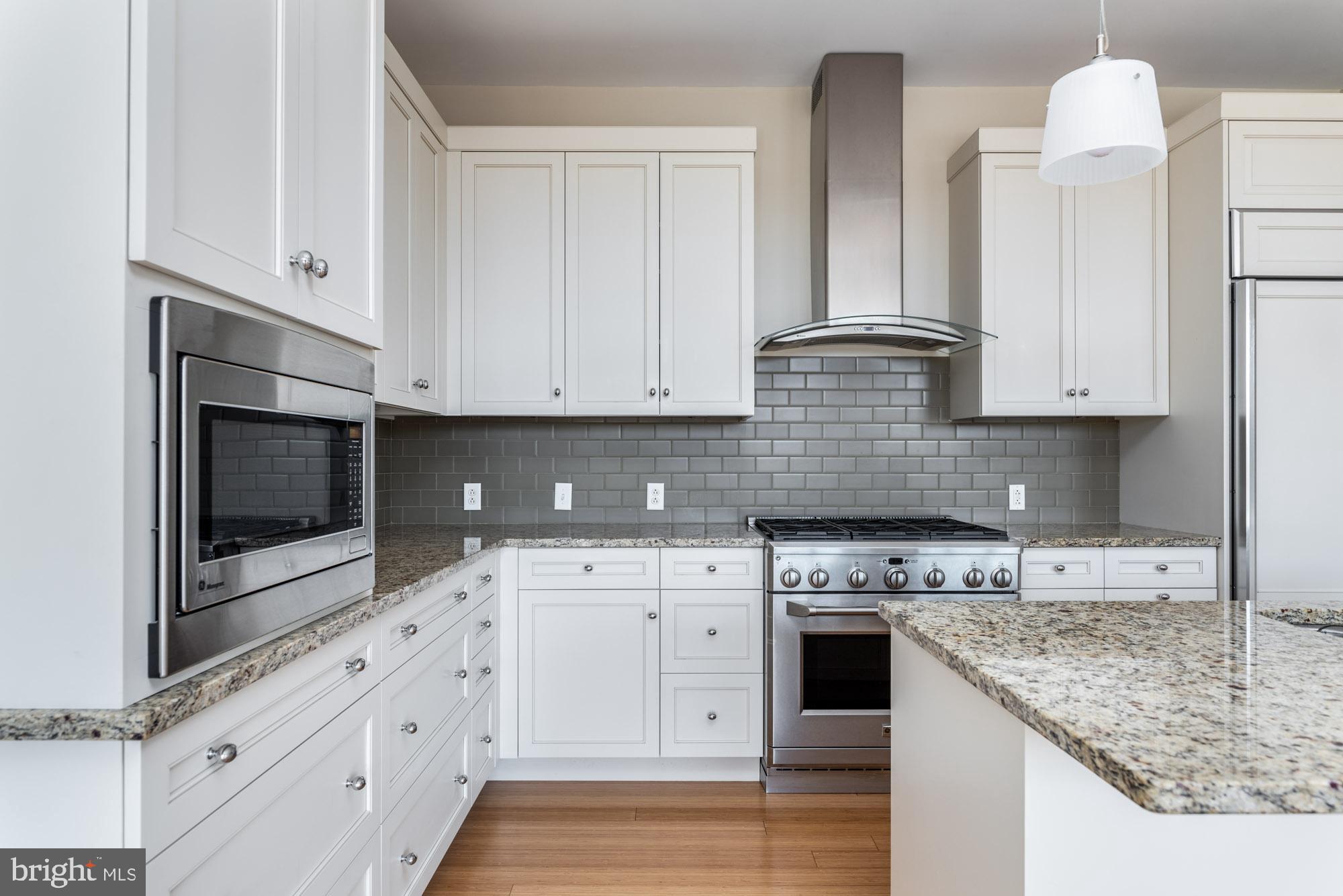 223 Iron Works Way Wayne, PA 19087 - Photo 6 of 23 a kitchen with stainless steel appliances granite countertop a stove a sink and a microwave
