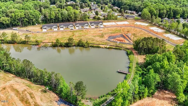 an aerial view of residential houses with outdoor space and lake view