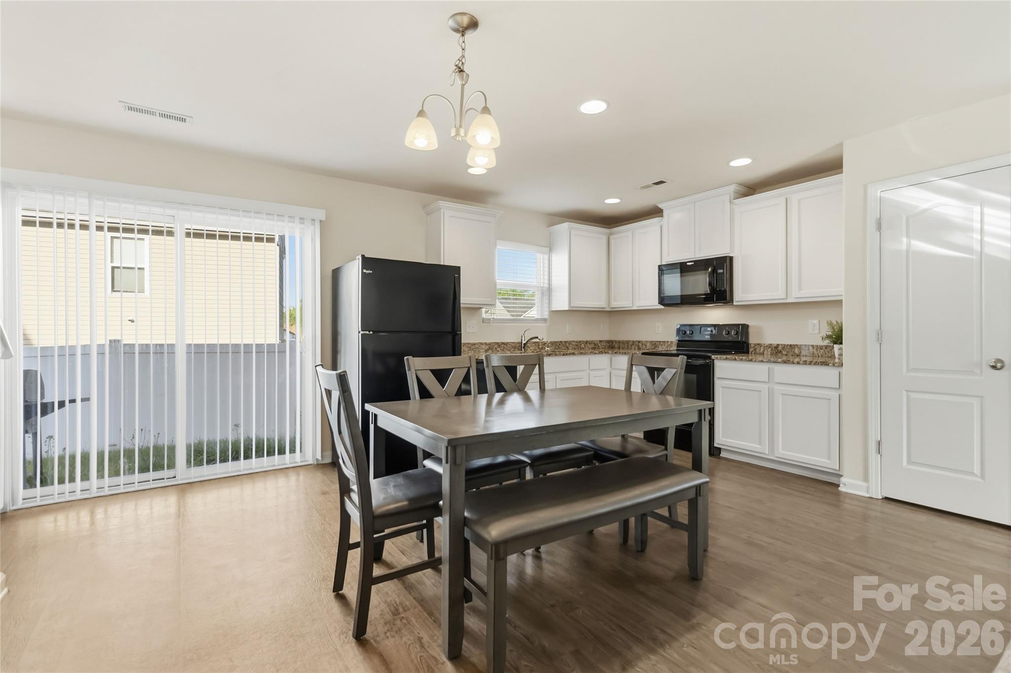14015 Rory Glen Lane Charlotte, NC 28215 - Photo 11 of 28 a kitchen with a table chairs microwave and refrigerator