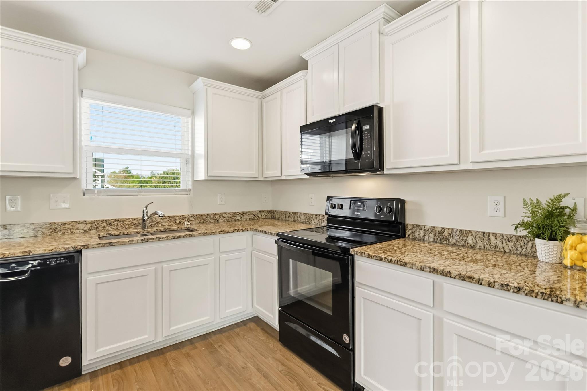 14015 Rory Glen Lane Charlotte, NC 28215 - Photo 12 of 28 a kitchen with granite countertop white cabinets sink and stainless steel appliances