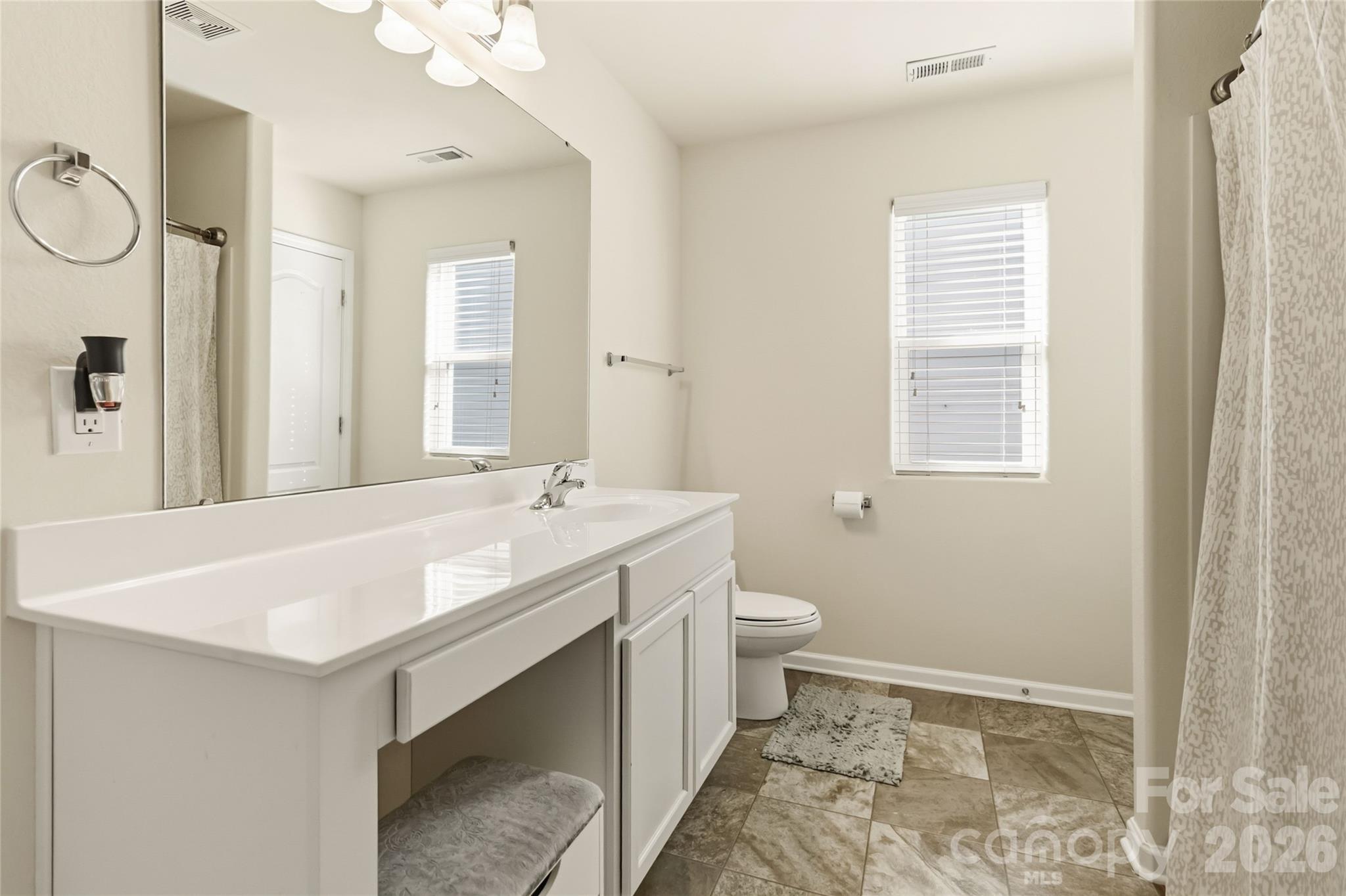 14015 Rory Glen Lane Charlotte, NC 28215 - Photo 21 of 28 a bathroom with a sink a toilet and a mirror