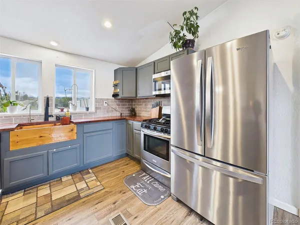 a kitchen with stainless steel appliances a refrigerator sink and cabinets