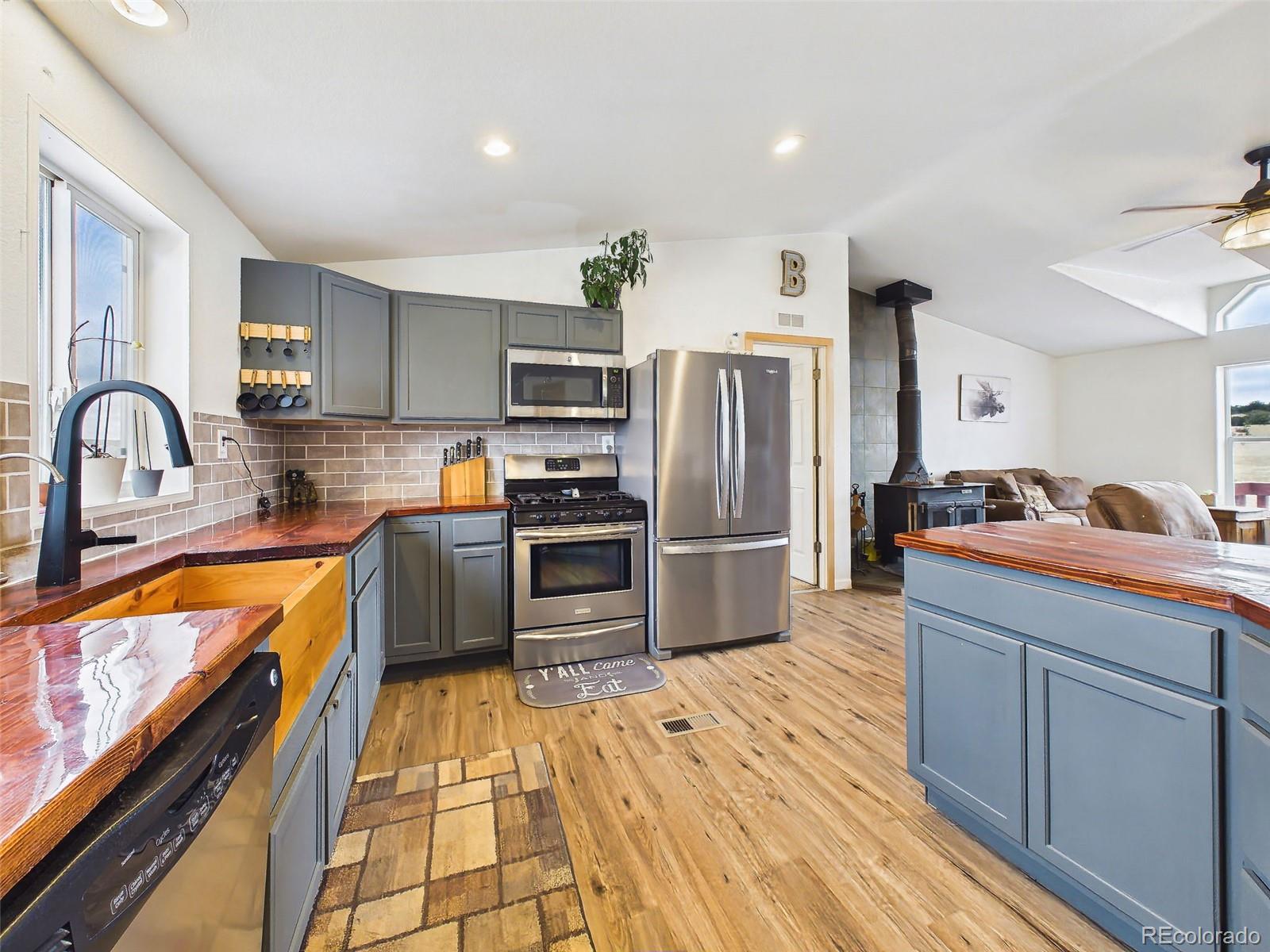 699 Cedar Hills Road Penrose, CO 81240 - Photo 13 of 50 a kitchen with stainless steel appliances a refrigerator sink and cabinets