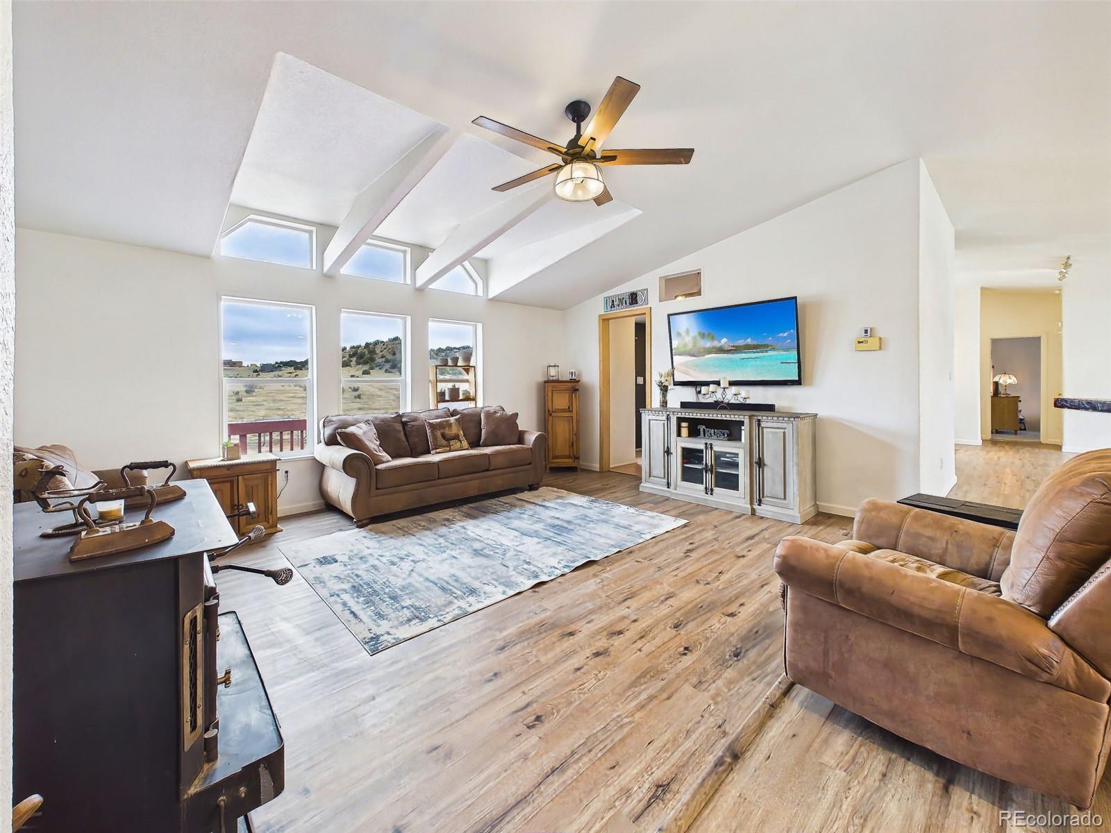 699 Cedar Hills Road Penrose, CO 81240 - Photo 20 of 50 a living room with furniture kitchen view and a wooden floor