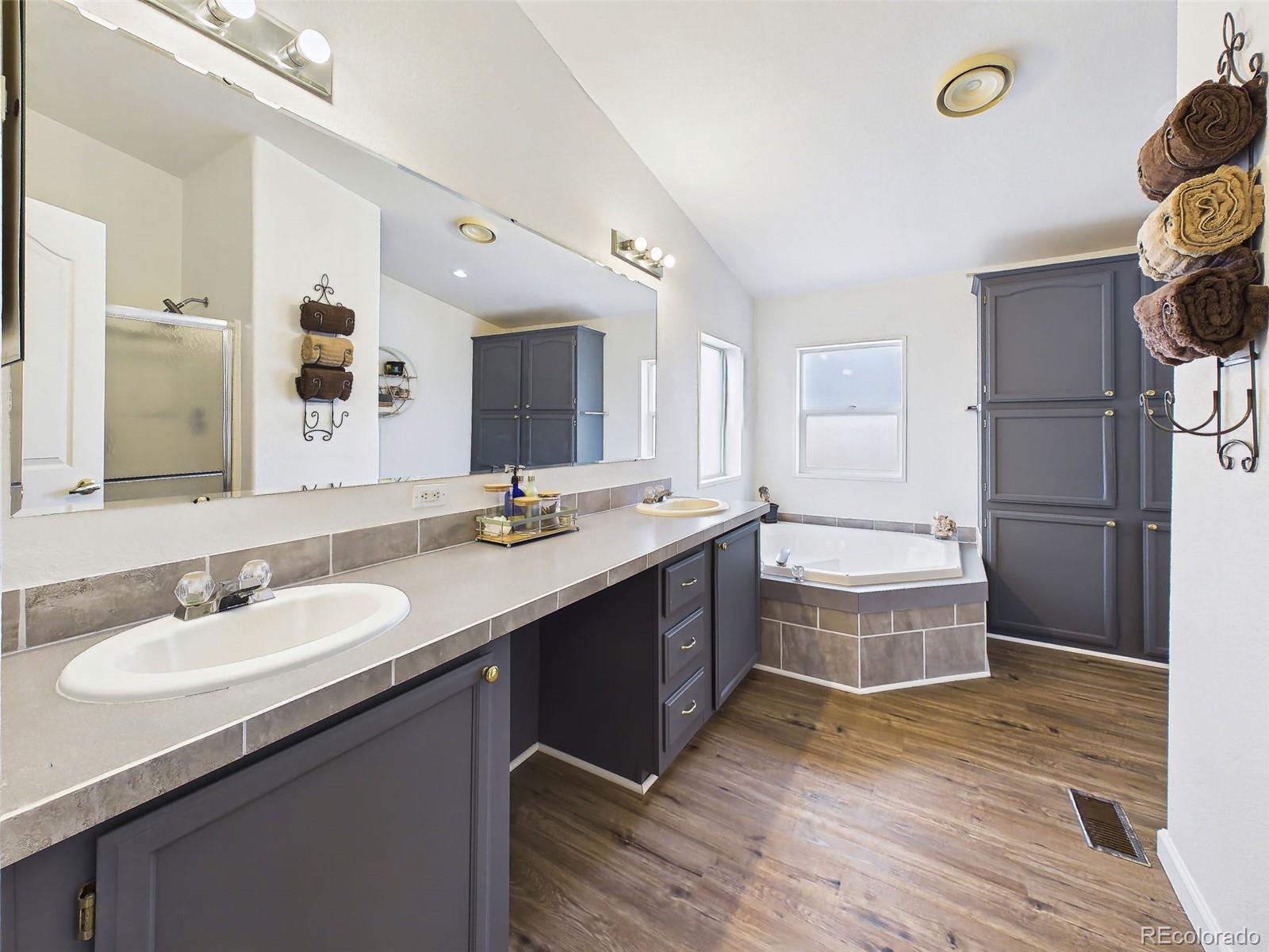 699 Cedar Hills Road Penrose, CO 81240 - Photo 23 of 50 a bathroom with a granite countertop double vanity sink a mirror and a shower
