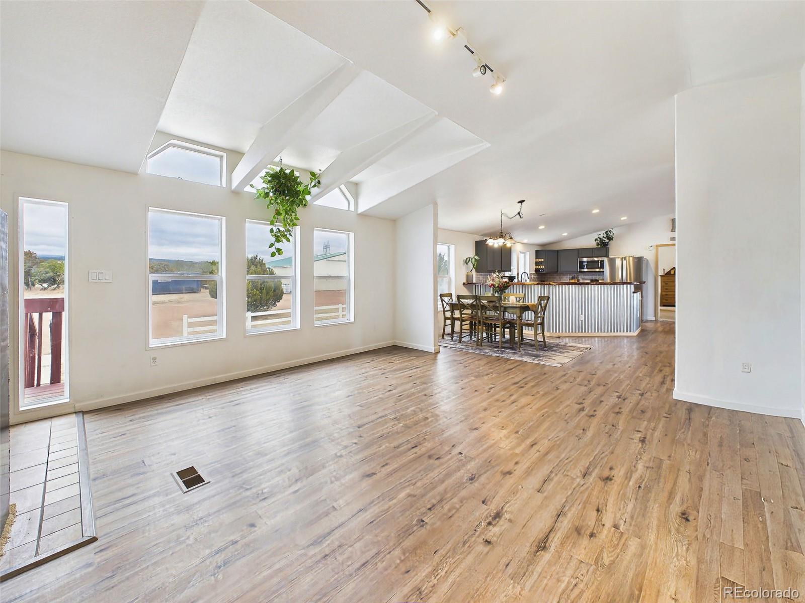 699 Cedar Hills Road Penrose, CO 81240 - Photo 5 of 50 a view of a living room and dining room with wooden floor