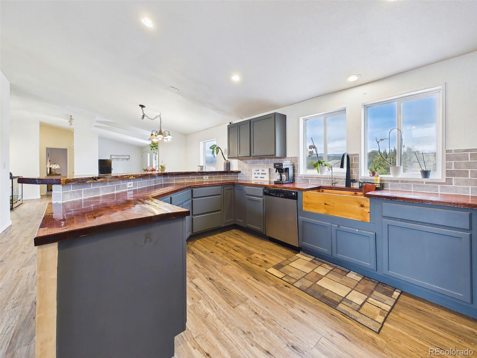699 Cedar Hills Road Penrose, CO 81240 - Photo 9 of 50 a kitchen with stainless steel appliances granite countertop a sink stove and wooden cabinets