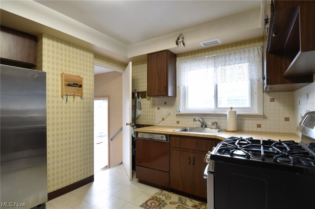 28740 Forest Road Willowick, OH 44095 - Photo 8 of 27 Kitchen featuring light tile floors, sink, tasteful backsplash, stainless steel appliances, and countertops light
