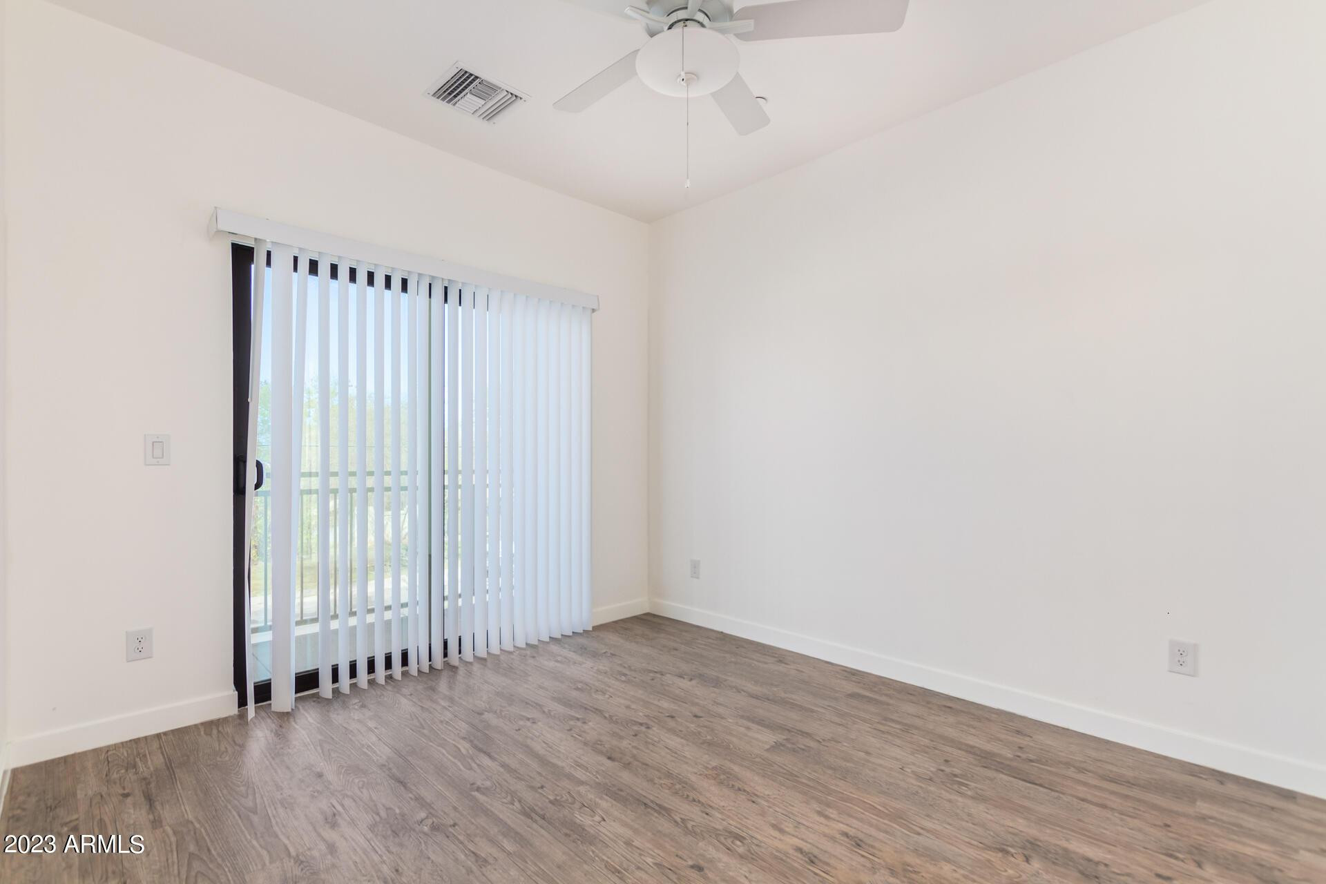 2063 East Lemon Street, Unit 2004 Tempe, AZ 85281 - Photo 17 of 25 an empty room with wooden floor and fan