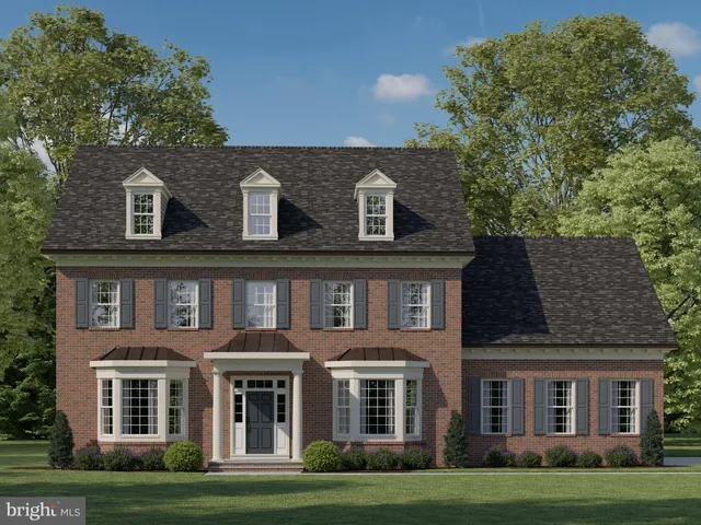 front view of a brick house with a big yard and large trees