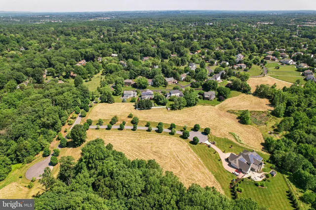 an aerial view of a house with a yard and swimming pool