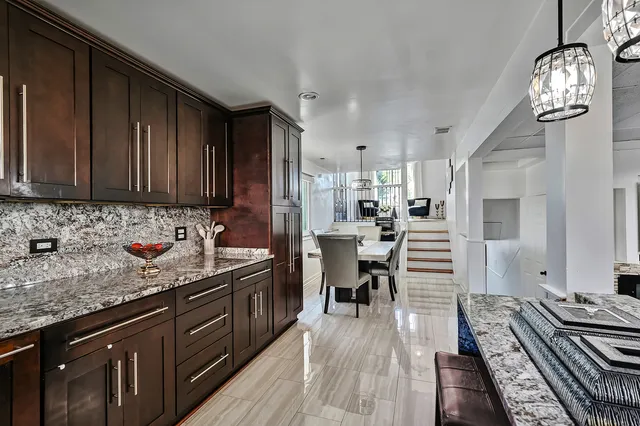 a kitchen with granite countertop lots of counter top space a sink and stainless steel appliances