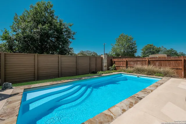 a front view of a house with swimming pool table and chairs