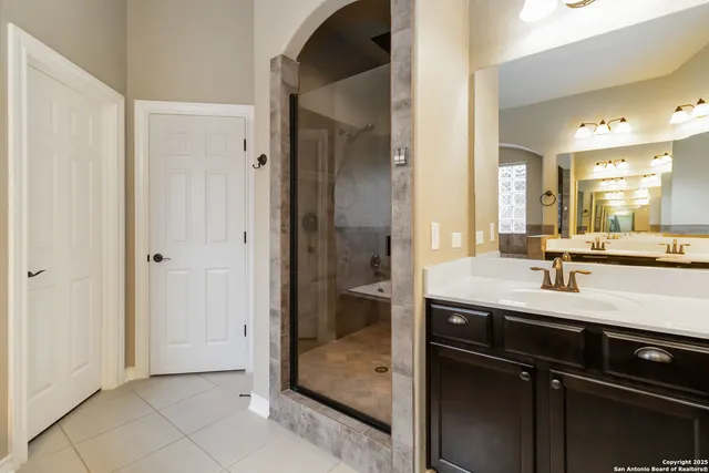a bathroom with a granite countertop sink two mirror and a shower