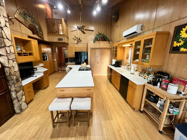 a kitchen with stainless steel appliances granite countertop a stove a sink a dining table and chairs with wooden floor