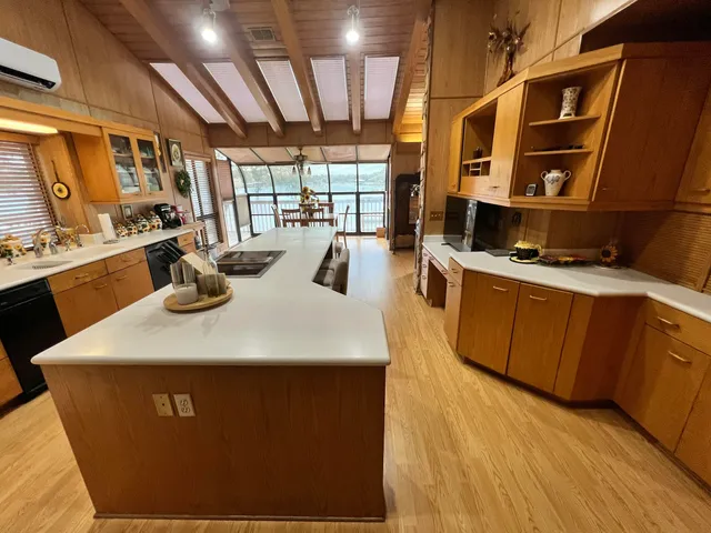 a kitchen with stainless steel appliances kitchen island granite countertop a table chairs sink and cabinets