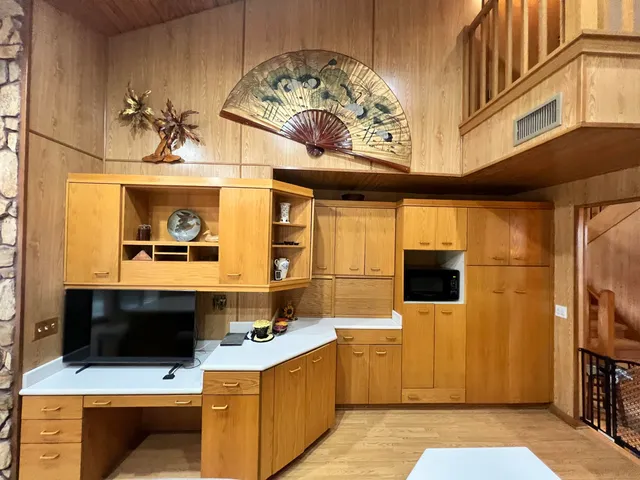 a large kitchen with stainless steel appliances kitchen island granite countertop a large counter top couches and furniture