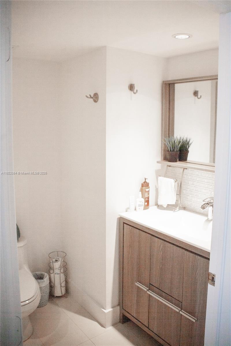 6301 Collins Avenue, Unit 807 Miami Beach, FL 33141 - Photo 16 of 42 a bathroom with a sink a toilet and a mirror
