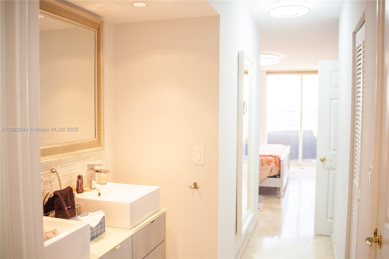 6301 Collins Avenue, Unit 807 Miami Beach, FL 33141 - Photo 20 of 42 a en suite bathroom with a sink and a mirror