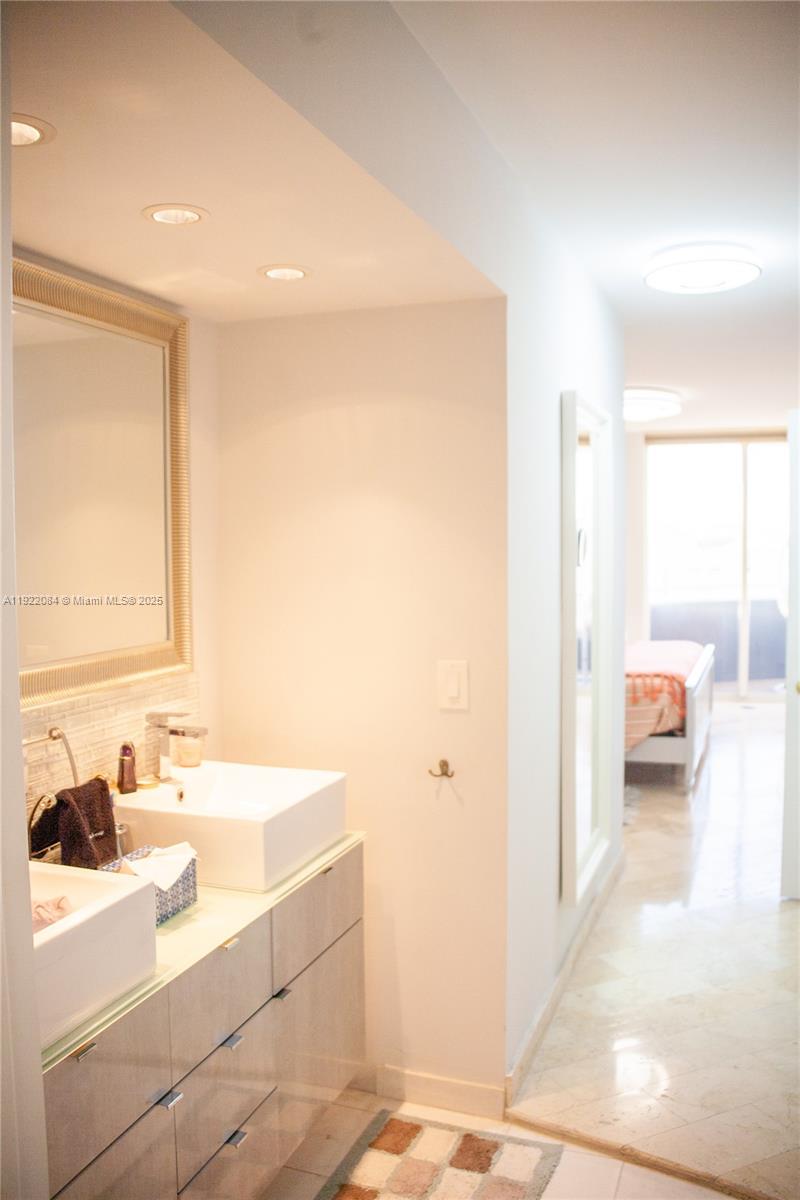6301 Collins Avenue, Unit 807 Miami Beach, FL 33141 - Photo 21 of 42 a en suite bathroom with a sink and a mirror
