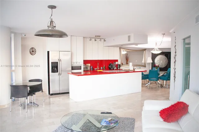 a view of a kitchen with kitchen island stainless steel appliances a sink and counter space