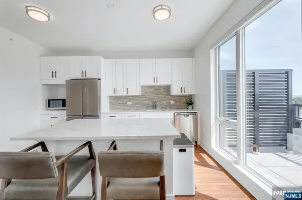a kitchen with a table chairs refrigerator and cabinets