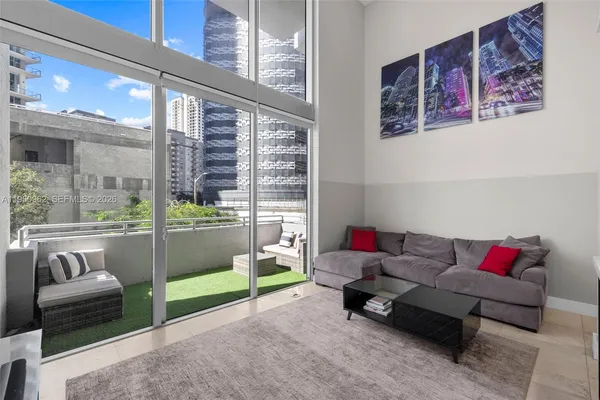 a living room with furniture and a floor to ceiling window