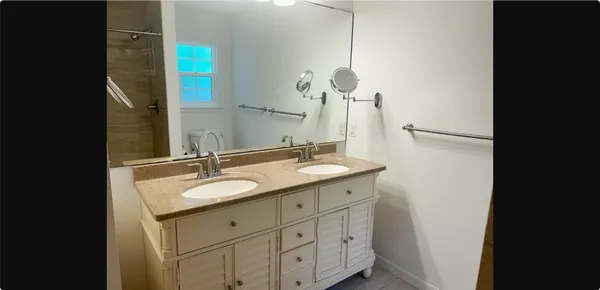 a bathroom with a granite countertop sink and a mirror