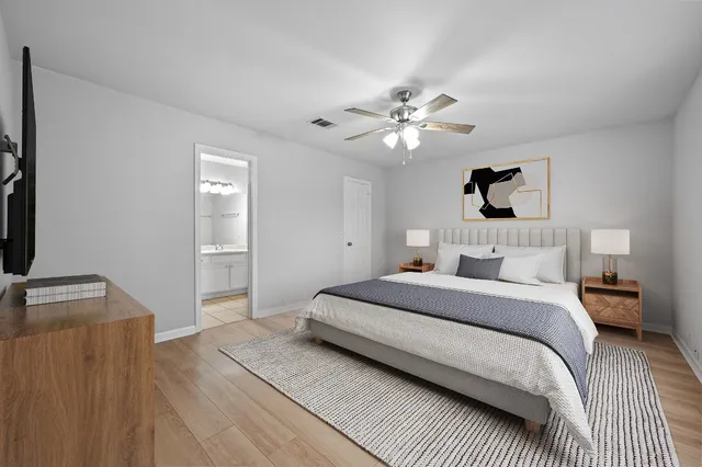 a spacious bedroom with a bed and a chandelier