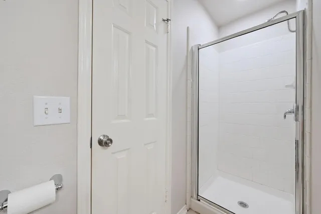 a bathroom with a shower and a glass door