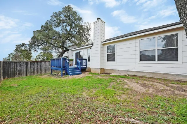 a backyard of a house with wooden floor and fence