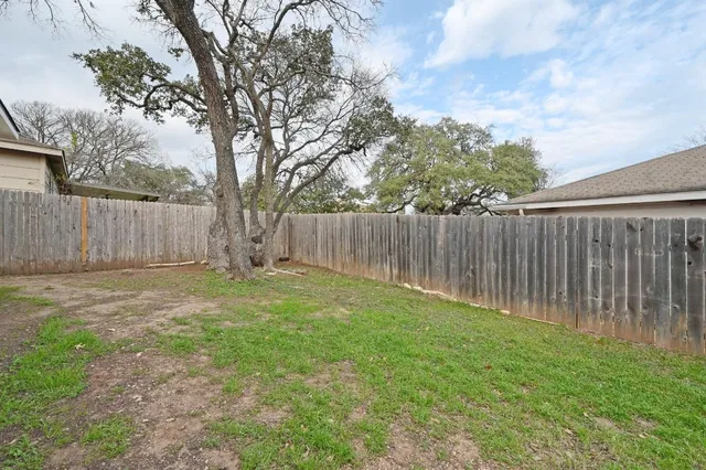 a view of a backyard with wooden fence