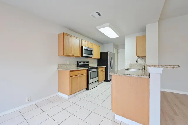 a kitchen with stainless steel appliances granite countertop a stove a sink and a refrigerator
