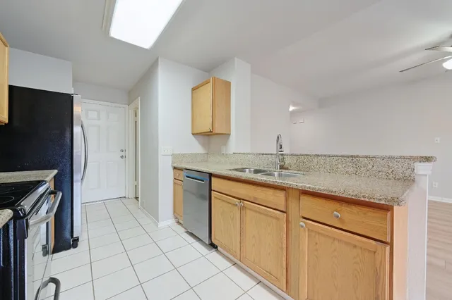 a kitchen with stainless steel appliances granite countertop a sink and a refrigerator