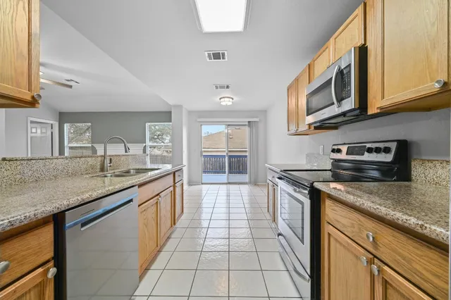 a kitchen with stainless steel appliances granite countertop a sink and dishwasher a stove top oven with wooden floor