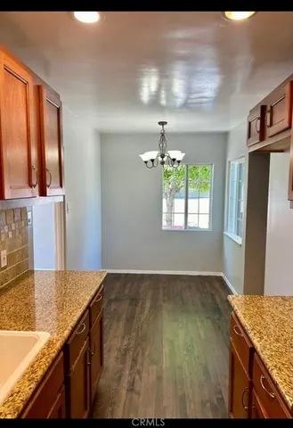 a kitchen with kitchen island a sink wooden floor and a refrigerator