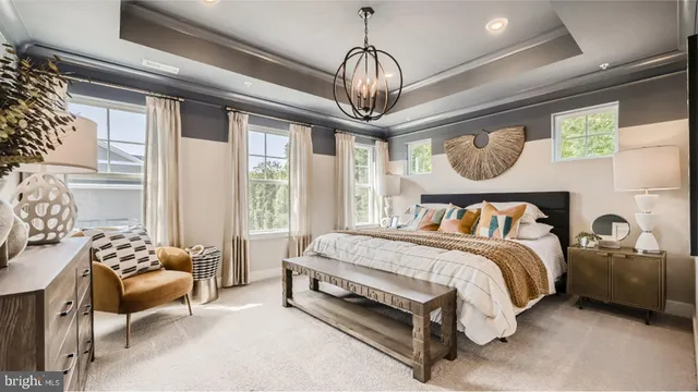 a spacious bedroom with a bed and a chandelier