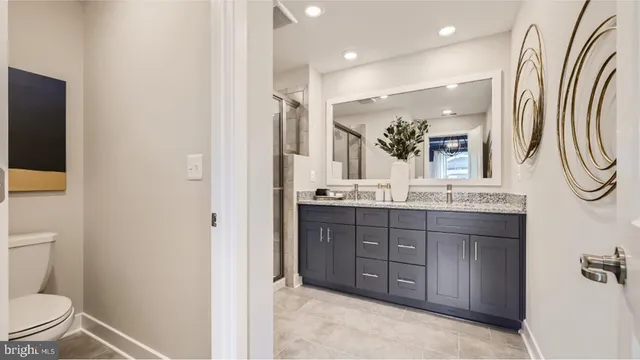 a bathroom with a double vanity sink mirror and toilet