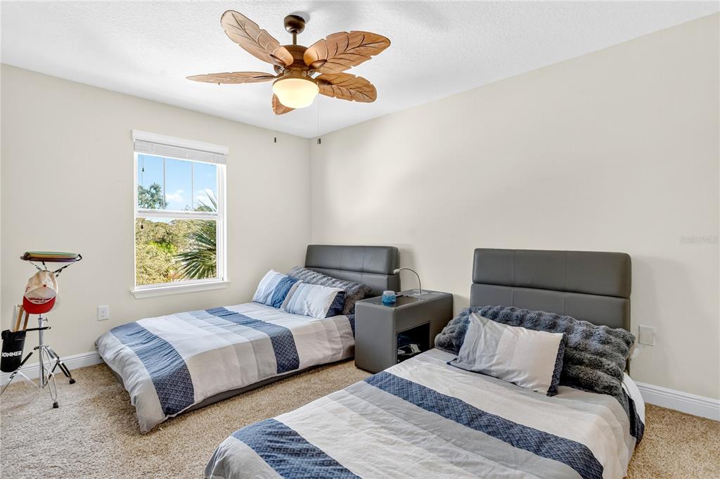 9009 Palm Key Avenue Oldsmar, FL 34677 - Photo 18 of 38 a bedroom with two beds and a chandelier