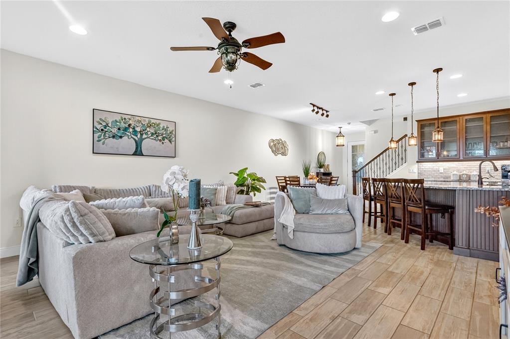 9009 Palm Key Avenue Oldsmar, FL 34677 - Photo 5 of 38 a living room with furniture kitchen view and a wooden floor