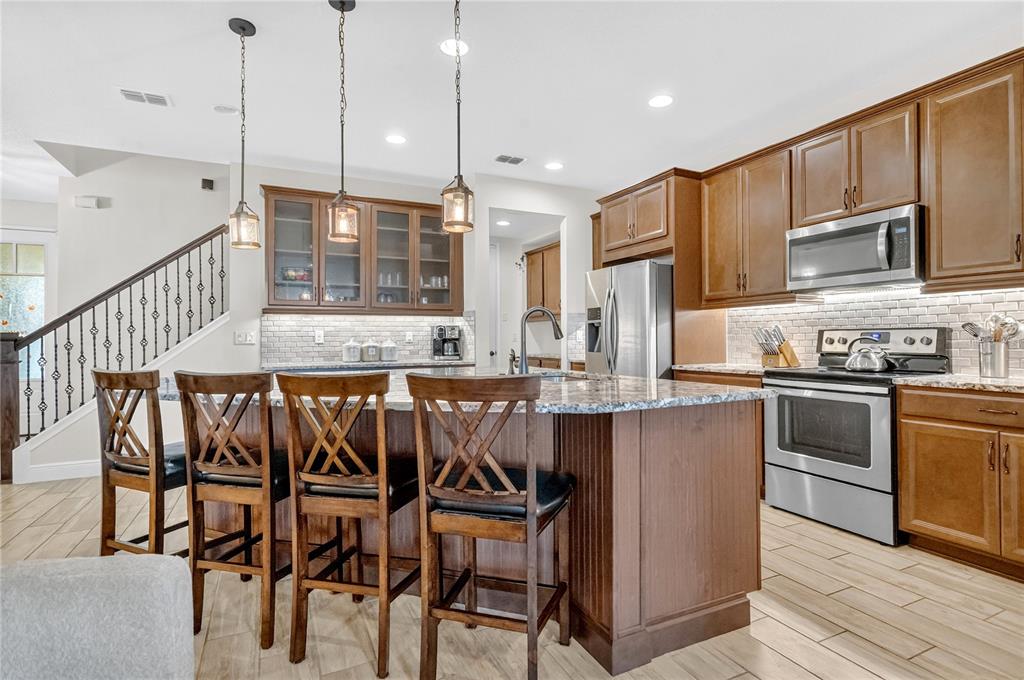 9009 Palm Key Avenue Oldsmar, FL 34677 - Photo 7 of 38 a kitchen with stainless steel appliances granite countertop a kitchen island a stove a sink and a refrigerator