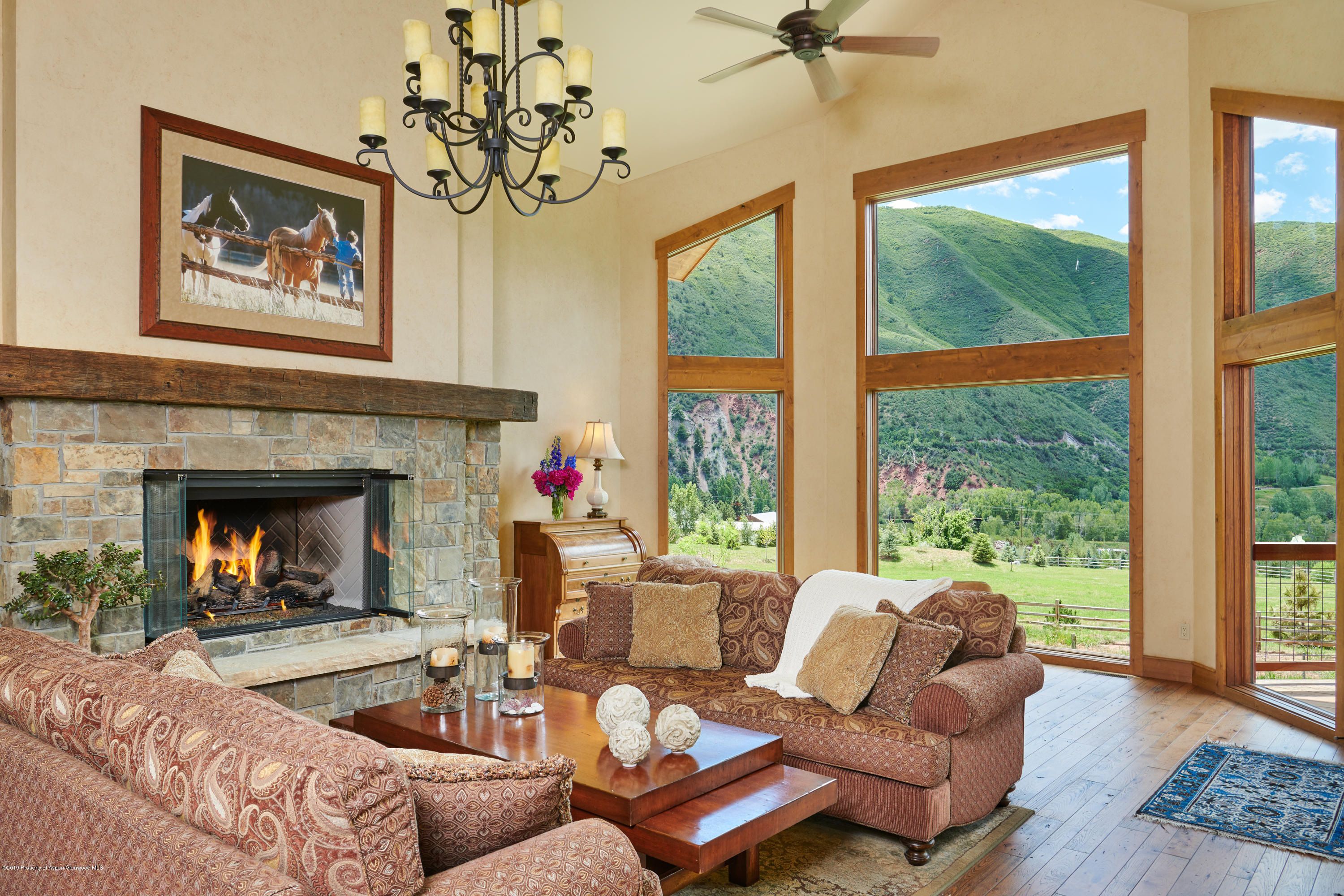 642 Holland Hills Road Basalt, CO 81621 - Photo 3 of 27 a living room with furniture a large window and a fireplace