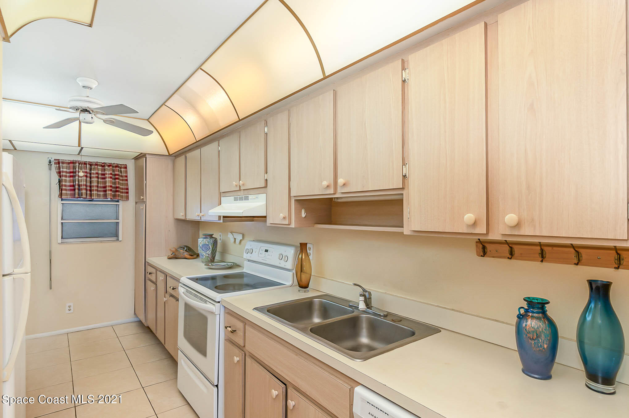 416 School Road, Unit 102 Indian Harbour Beach, FL 32937 - Photo 4 of 27 a kitchen with sink cabinets and outdoor view