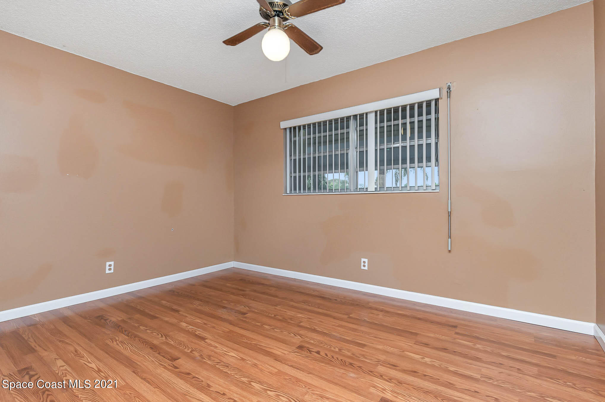 416 School Road, Unit 102 Indian Harbour Beach, FL 32937 - Photo 9 of 27 a view of empty room with wooden floor and fan