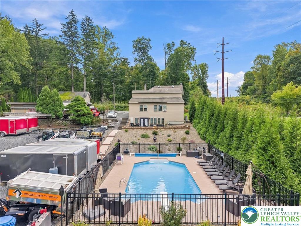 3771 State Road Coopersburg, PA 18036 - Photo 6 of 37 An inviting backyard oasis features a fenced inground pool surrounded by mature trees.