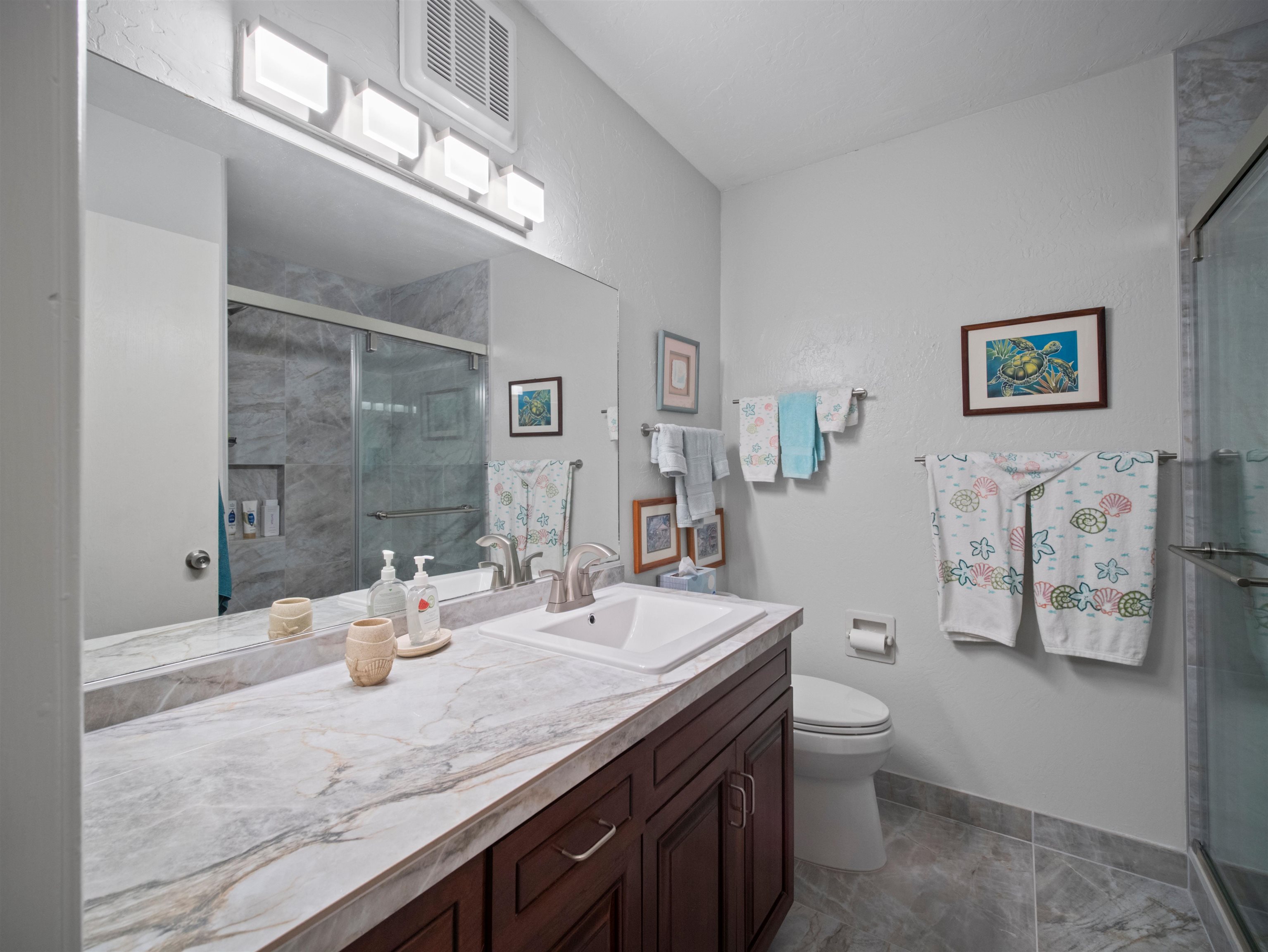 2737 South Kihei Road, Unit 1119 Kihei, HI 96753 - Photo 9 of 24 a bathroom with a granite countertop sink and a mirror with toilet