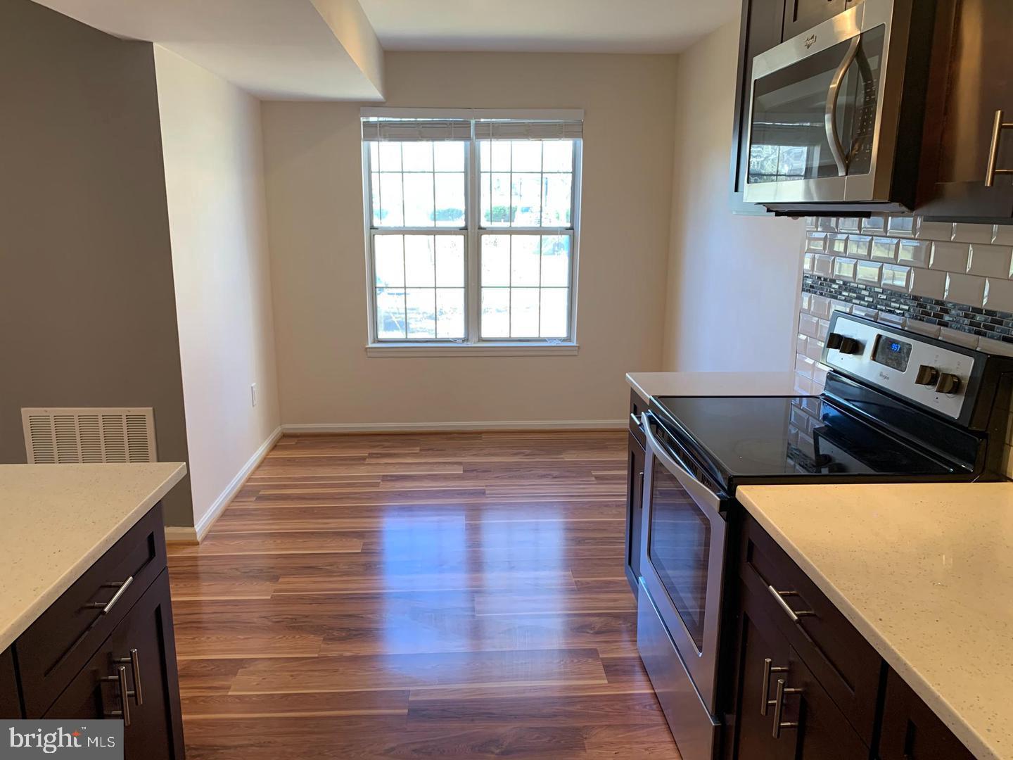 2 Normandy Square Court, Unit D Silver Spring, MD 20906 - Photo 10 of 32 a kitchen with wooden cabinets and a stove top oven