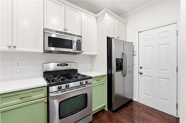 a kitchen with cabinets stainless steel appliances and wooden floor