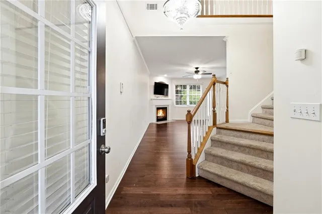 a view of a hallway with wooden floor and staircase