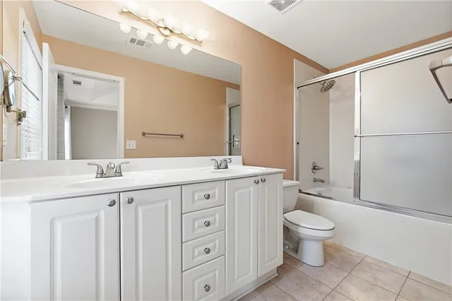 a bathroom with a granite countertop sink a toilet and a mirror